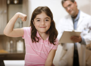 Picture of a young girl flexing at the doctor's office