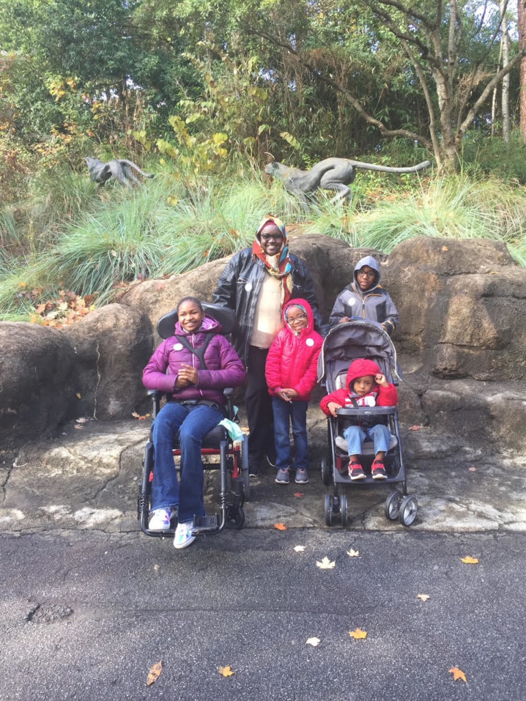 Ramatu and her four children smile and pose together for a picture.