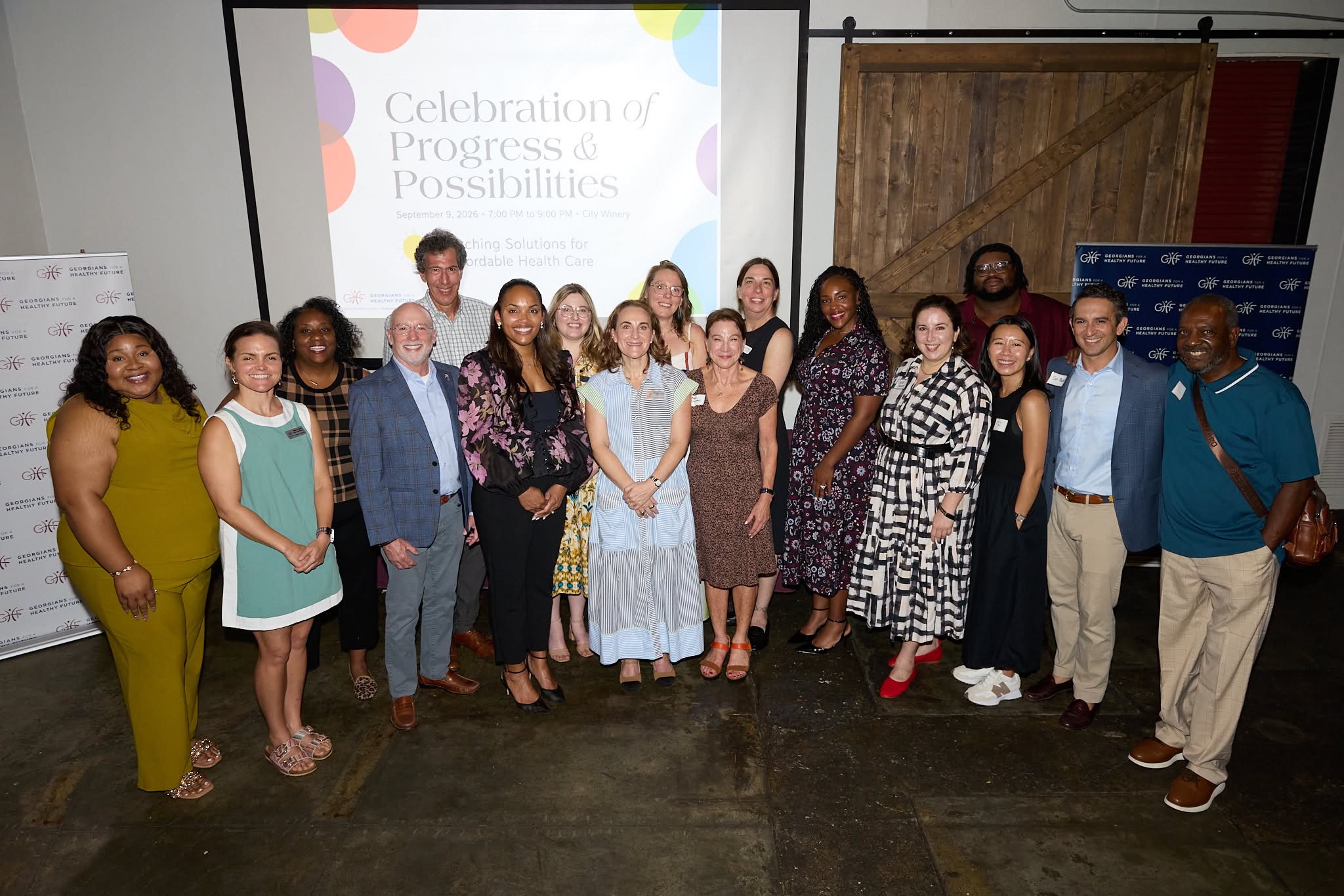 GHF staff and board members gather in front of the Celebration of Progress and Possibilities screen at City Winery Atlanta.